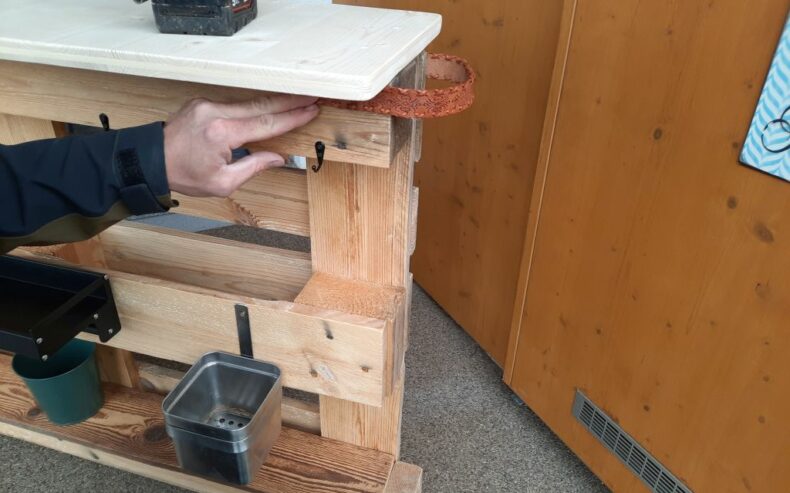 Ein Stück von einem alten Ledergürtel als Schlaufe zum Ziehen mit zwei Schrauben befestigen.
