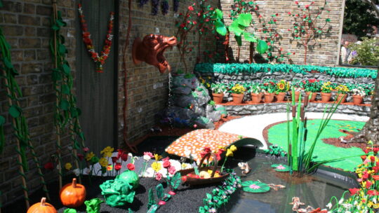 Gartenansicht mit Plastikpflanzen und Plastikdeko.