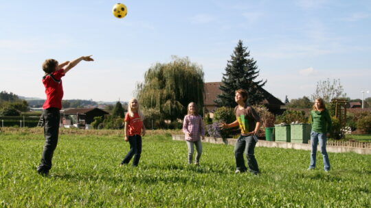 Kinder spielen Ball