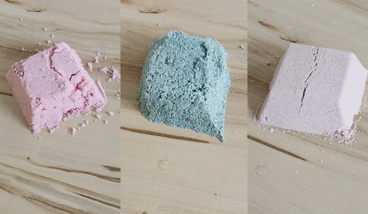 Drei Spielsandhäufchen ind ros, blau und natur