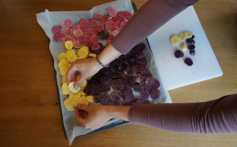 Kartoffelscheiben auf ein Backblech auflegen.