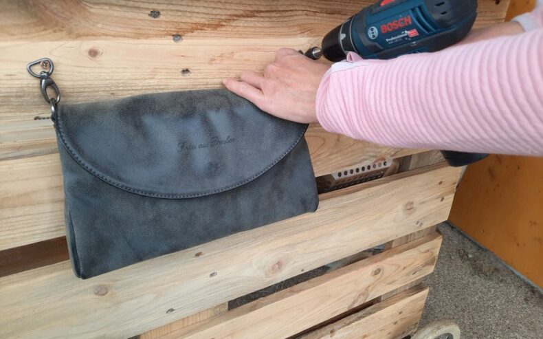 Auf der Rückseite der Palette eine Handtasche mit zwei Schrauben befestigen.