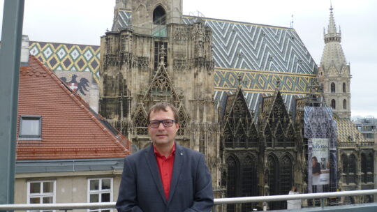 Markus Gerhartinger auf Terrasse mit Stephansdom im Hintergrund