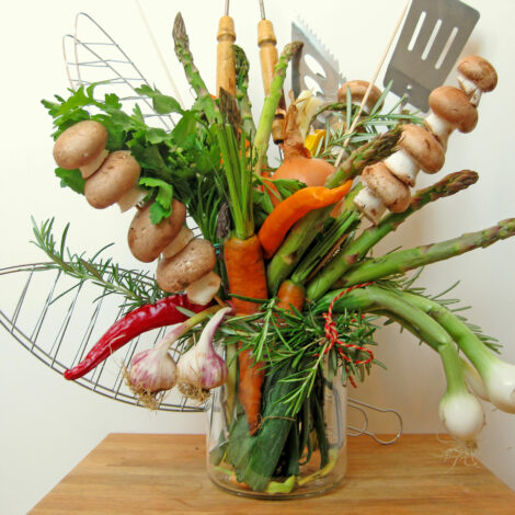 Gemüse wie Frühlingszwiebeln, Karotten, Spargel , Knoblauch zusammen mit Grillwerkzeug zu einem Strauß gebunden und in Vase gestellt