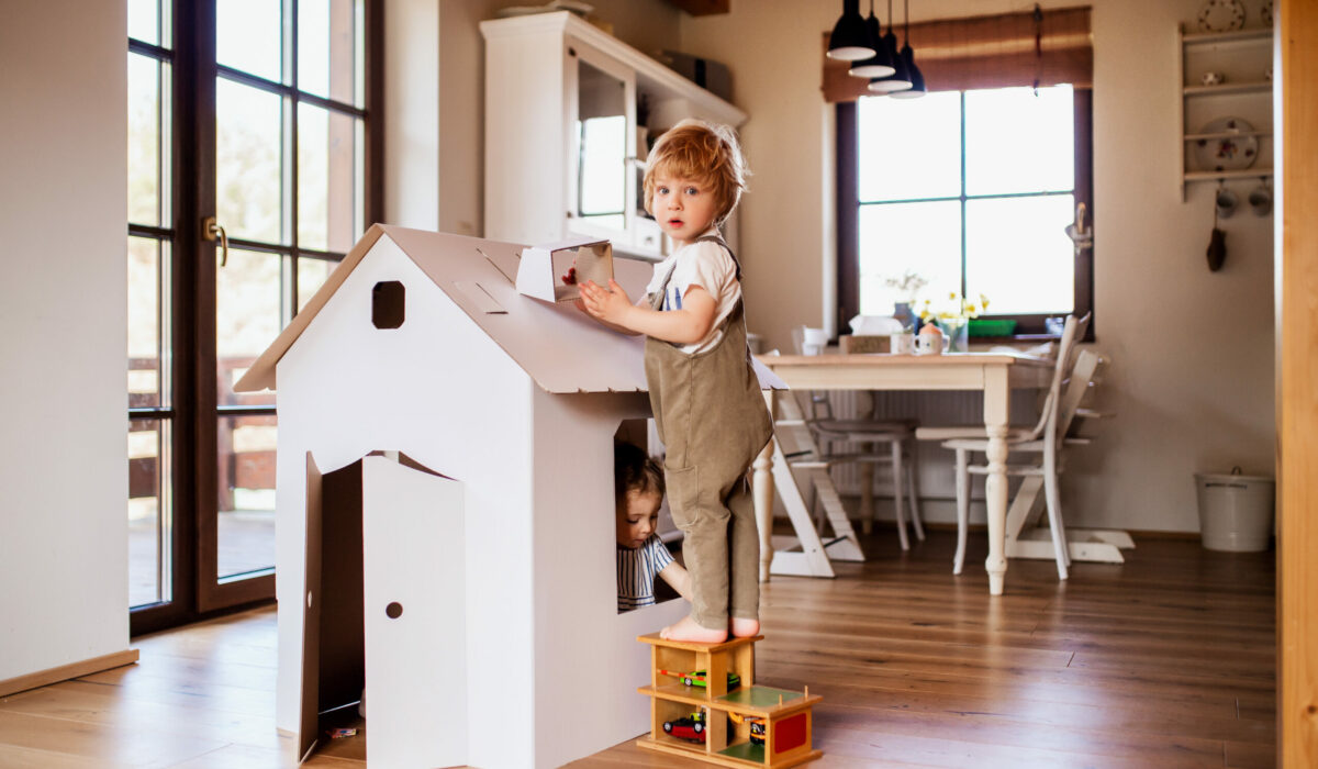 Kinder beim spielen zuhause mit einem Puppenhaus