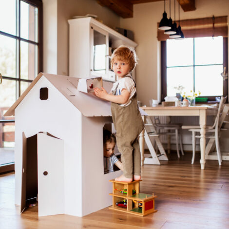 Kinder beim spielen zuhause mit einem Puppenhaus