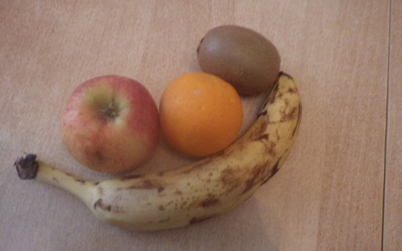 Apfel, Orange, Kiwi und Banane auf eine Tisch.