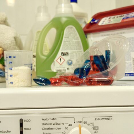 Waschmittel und Waschpads liegen auf Waschmaschine