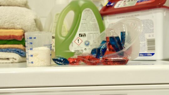Waschmittel und Waschpads liegen auf Waschmaschine