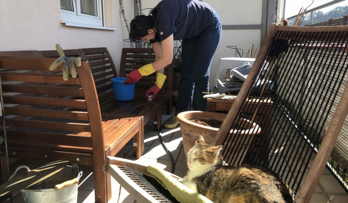 Frau bereitet den Balkon für die neue Saison vor