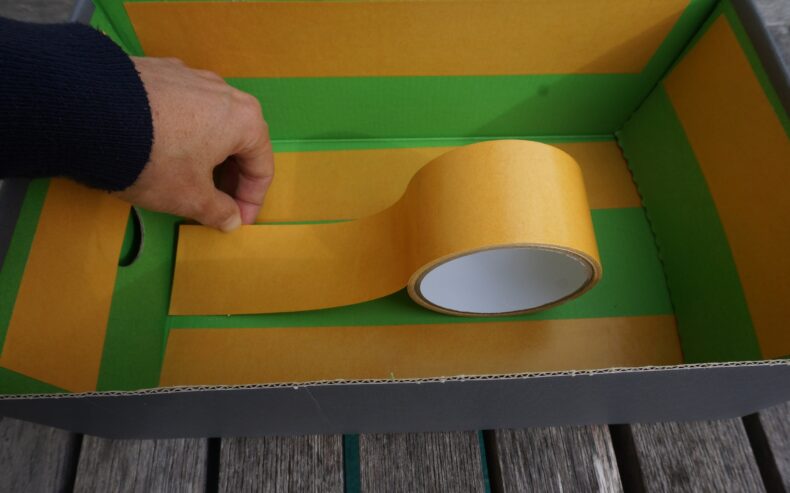 Schachtel mit doppelseitigem Klebeband bekleben