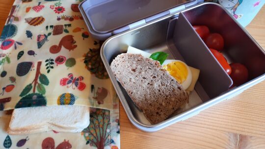 Gefüllte Jausenbox und Waschtücher mit Brot darin