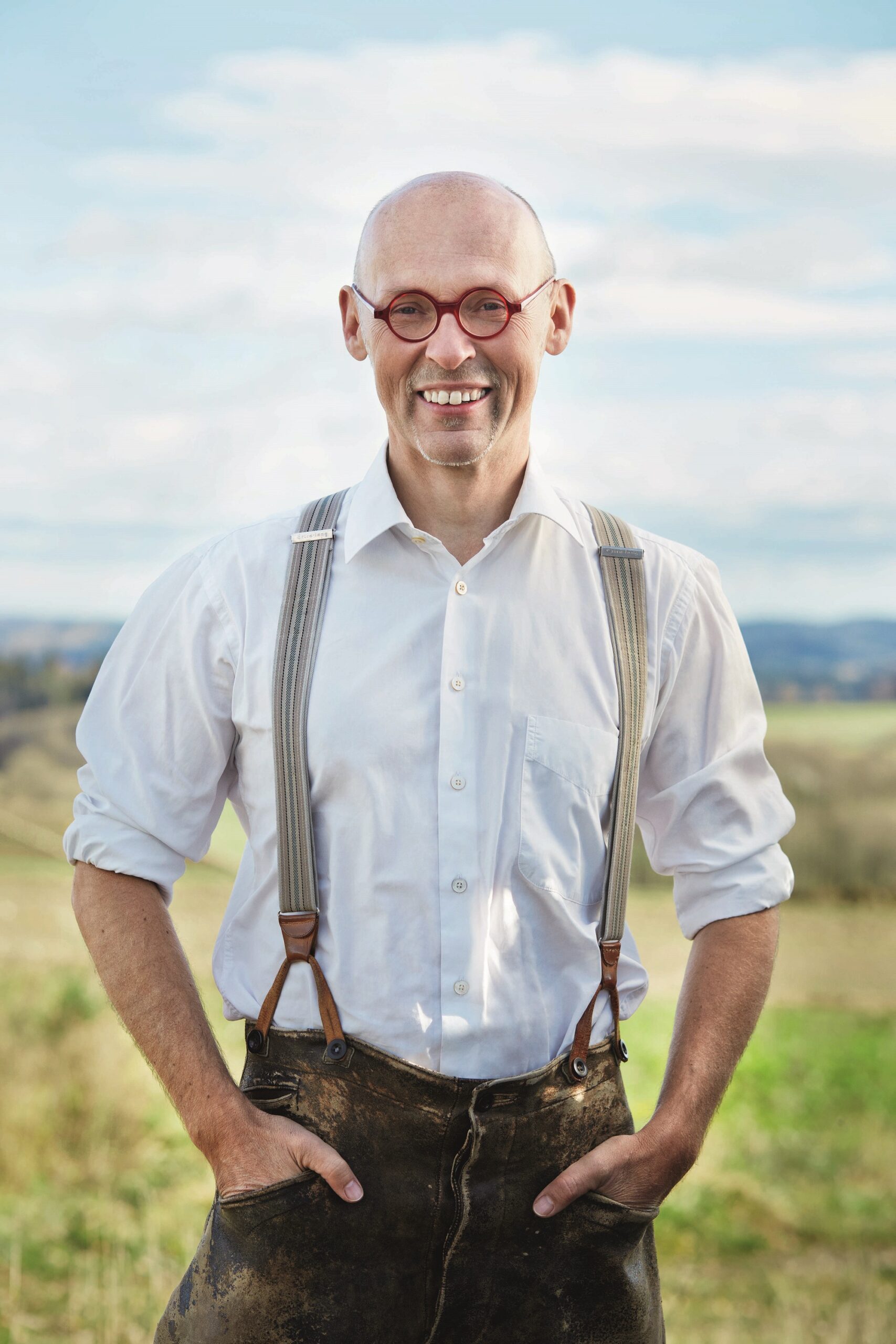 Johannes Gutmann steht im Freien vor einer grünen Landschaft