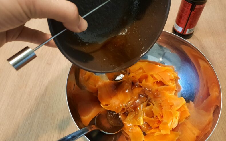 Die Marinade zu den Karottenstreifen geben und gut verrühren.