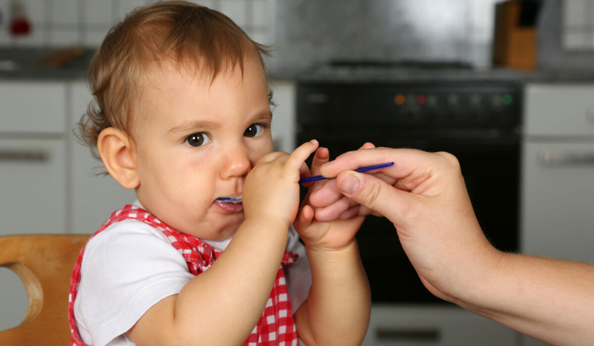 Baby wird mit Brei gefüttert.