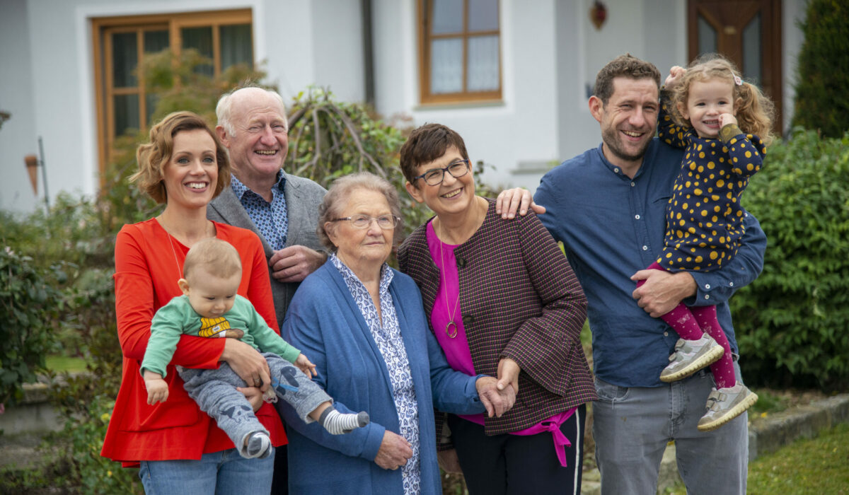 Familie mit mehreren Generationen stehen gemeinsam vor einem Haus