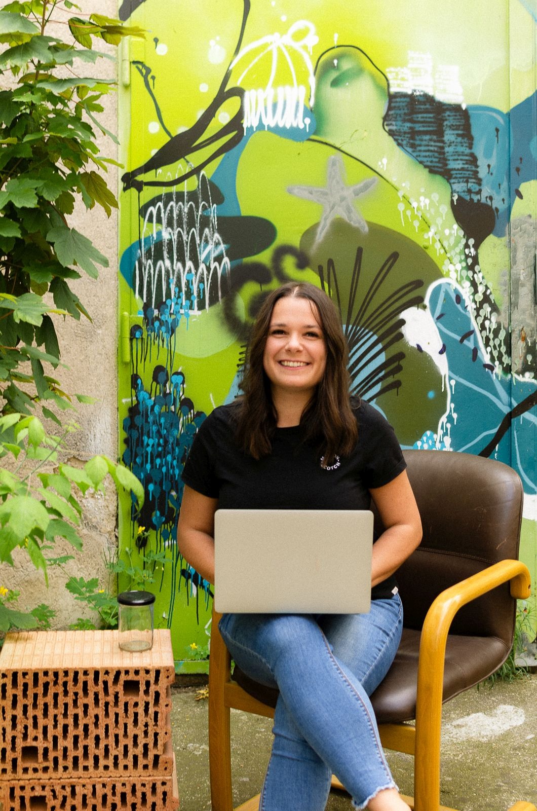 Daniela Hinteregger sitzt mit Laptop am Schoß auf einem Stuhl