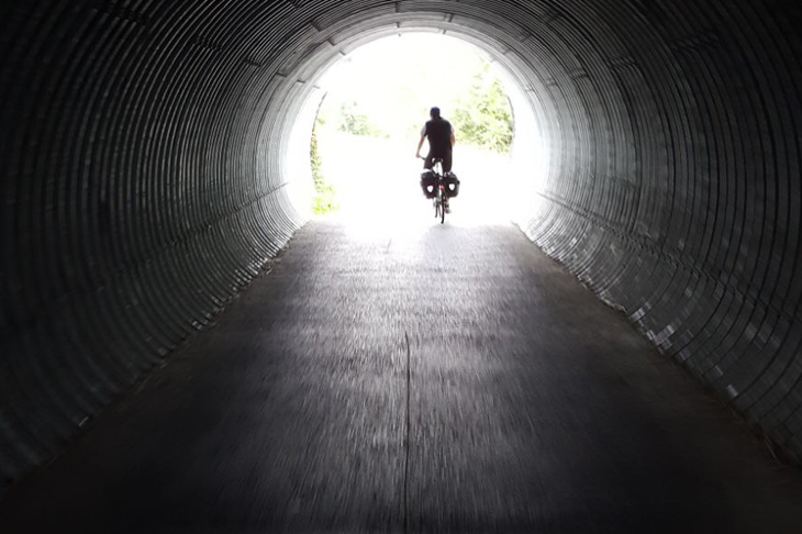 Radfahrer am Ende eines Tunnels