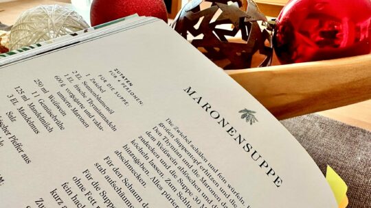 Aufgeschlagenes Rezeptbuch mit weihnachtlicher Dekoration.