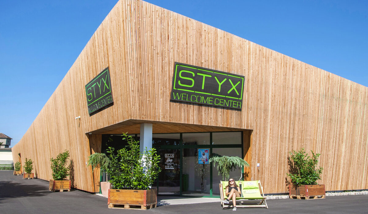 Firmengebäude Styx mit moderner Holzfassade und Trögen mit Pflanzen davor