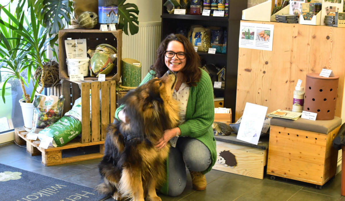 DI Sabine Pleininger, Geschäftsführerin von biohelp Garten & Bienen GmbH mit ihrem Hund im Geschäft von biohelp