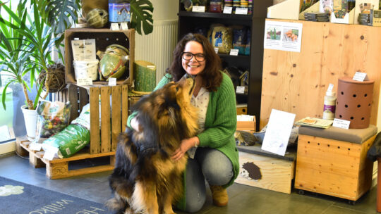 DI Sabine Pleininger, Geschäftsführerin von biohelp Garten & Bienen GmbH mit ihrem Hund im Geschäft von biohelp