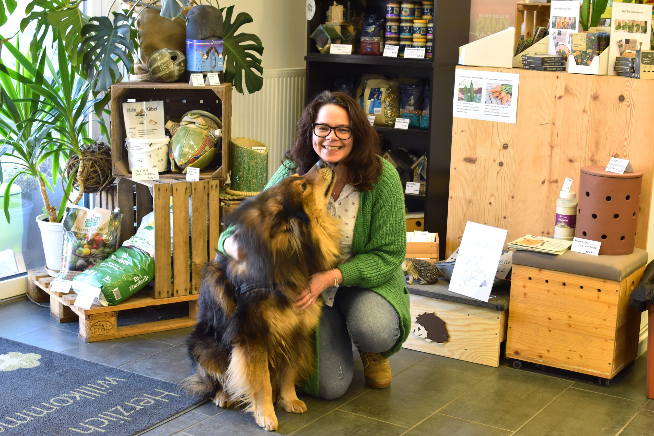 DI Sabine Pleininger, Geschäftsführerin von biohelp Garten & Bienen GmbH mit ihrem Hund im Geschäft von biohelp