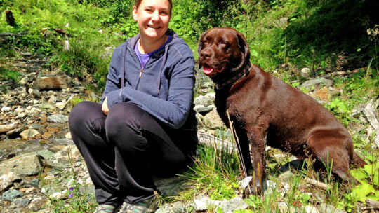 Silvia Osterkorn-Lederer mit ihrem Hund an einem Bach