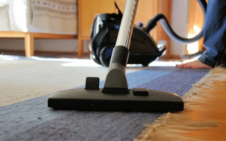 Teppich wird mit einem Staubsauger gereinigt.