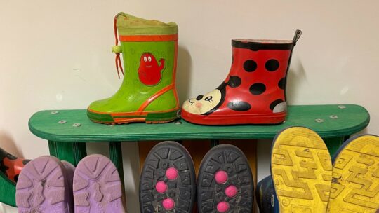 Kinder-Gummistiefel stehen auf einem Regal