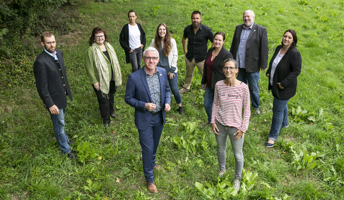 Team des Biosphärenparks Wienerwald stehen auf einer grünen Wiese.