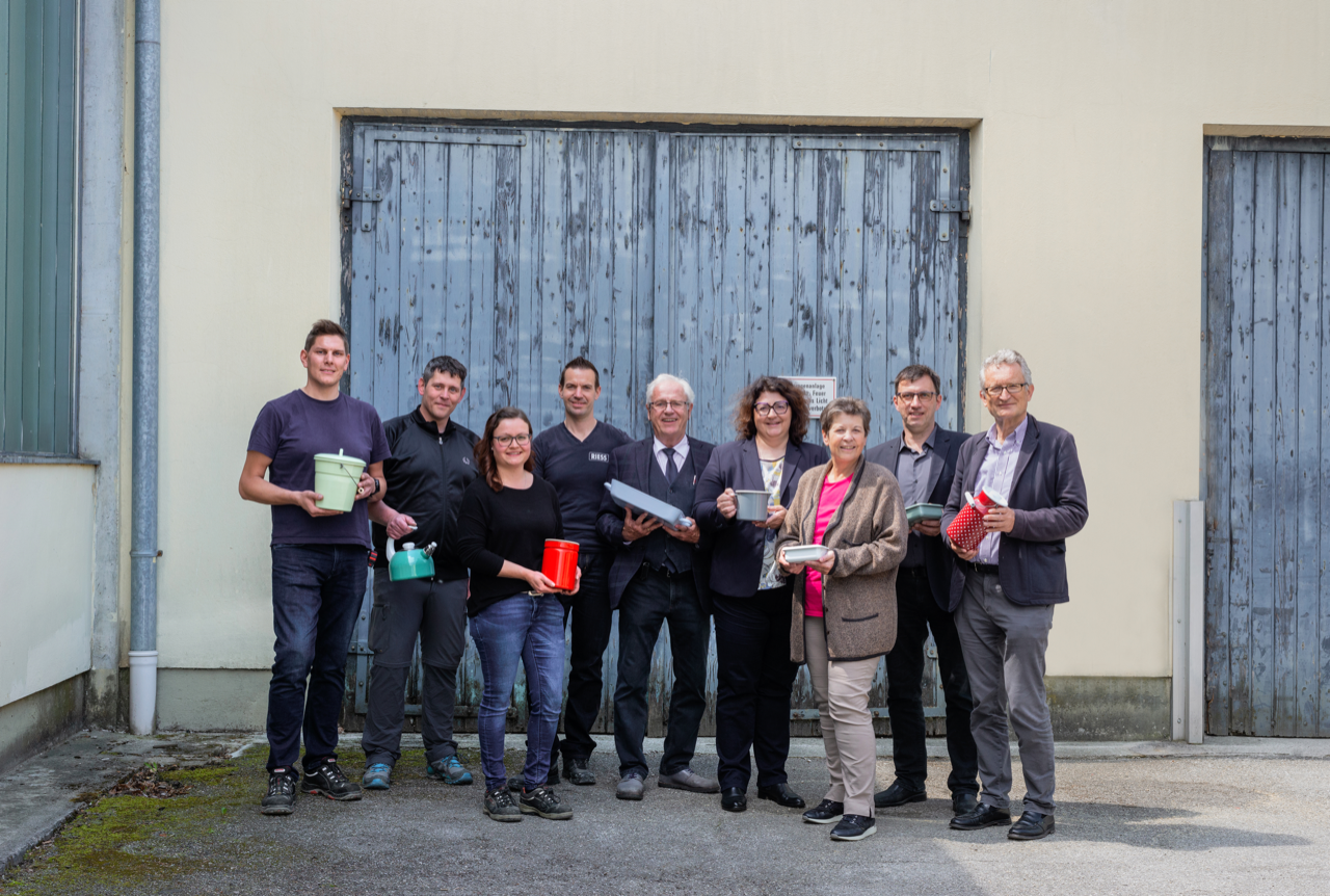 Teamfoto der Firma RIESS mit Geschirrwaren in den Händen