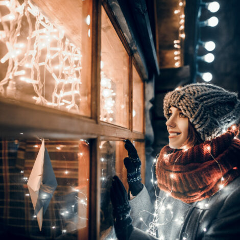 Frau bewundert Weihnachtsbeleuchtung auf Weihnachtsmarkt