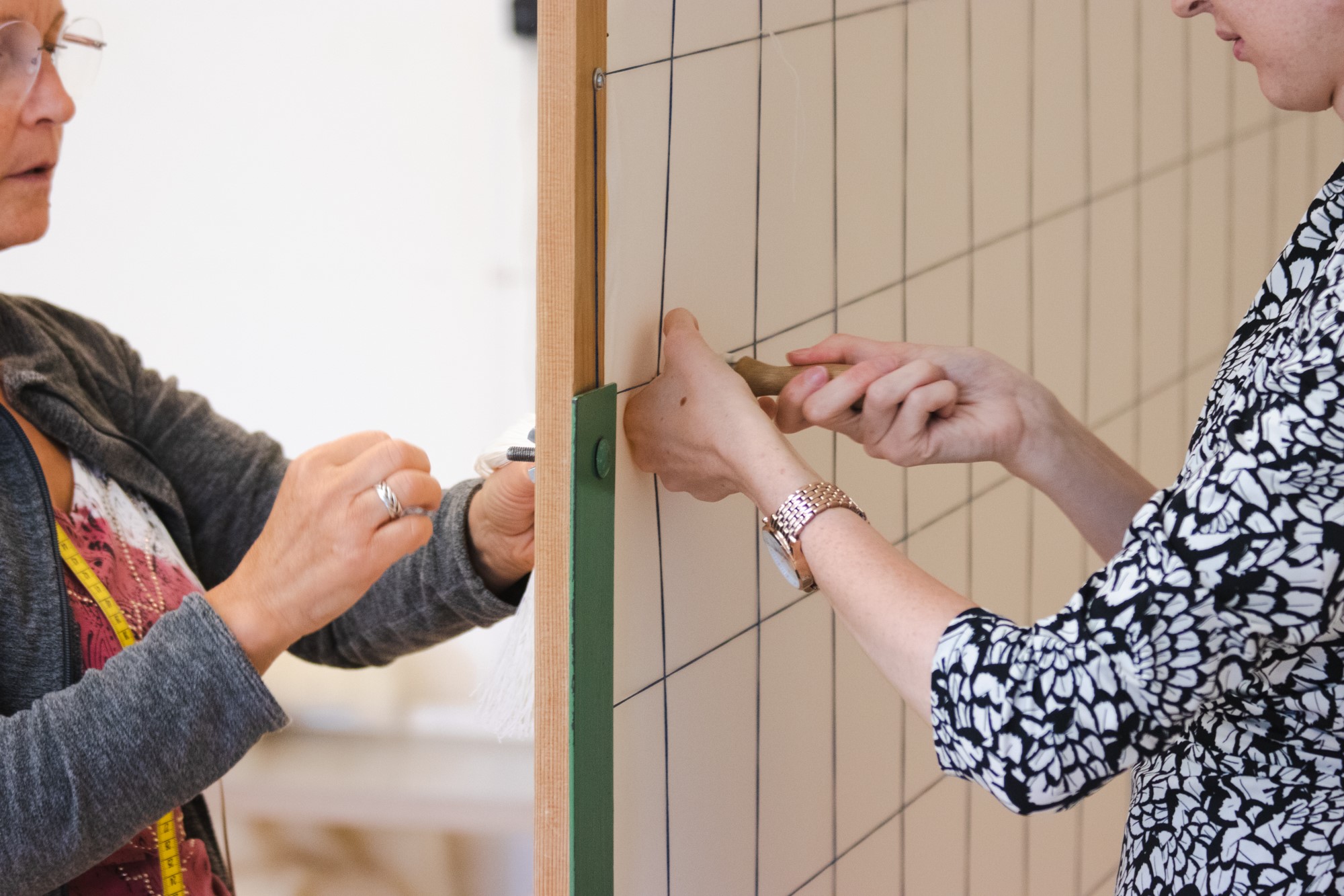 Zwei Mitarbeiterinnen arbeiten an einer Zwischenwand