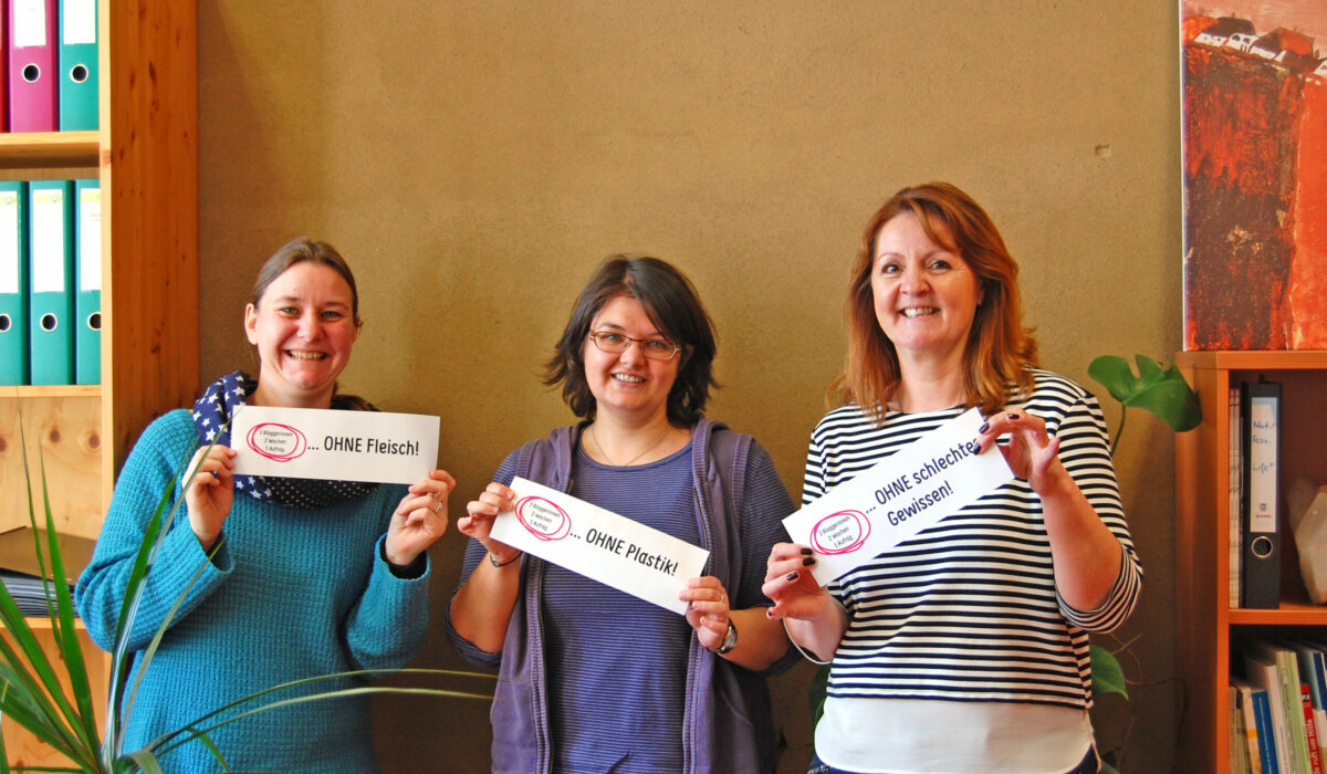 Silvia, Daniela und Christa halten Schilder mit ihren Aufgaben hoch.