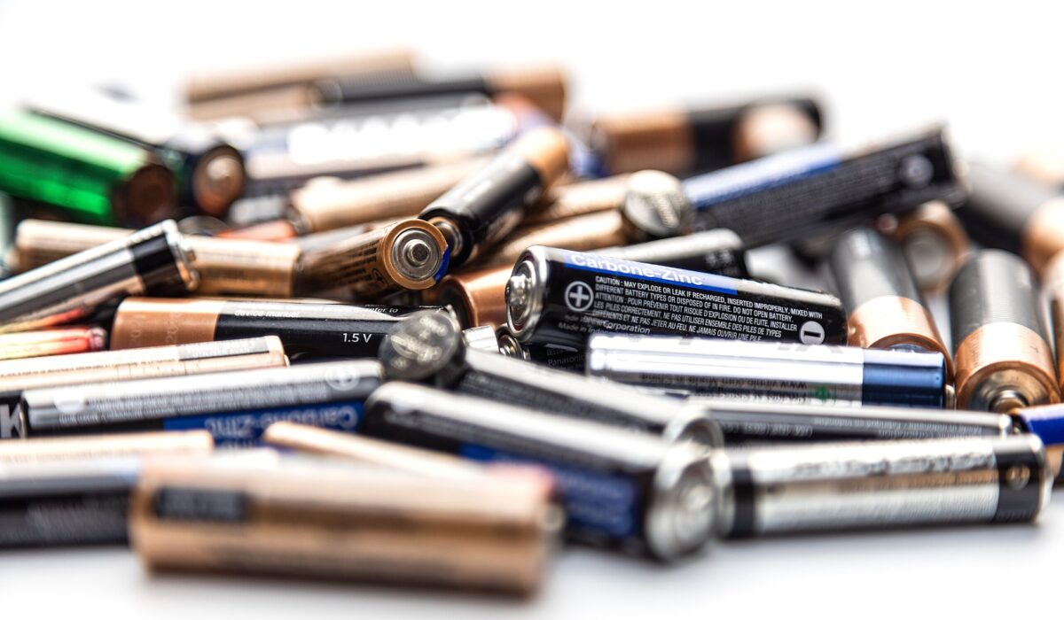Eine große Menge Batterien, unordentlich gestapelt auf einer festen Oberfläche