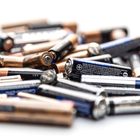 Eine große Menge Batterien, unordentlich gestapelt auf einer festen Oberfläche
