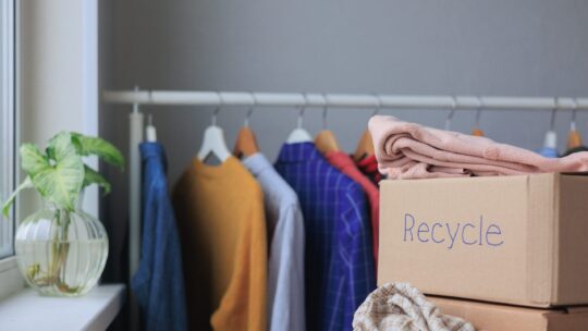 Kiste mit Kleidung für das Recycling. Müllsortierung und ein umweltfreundlicher Lebensstil.