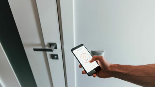 Mann versperrt die Haustür per Smartphone