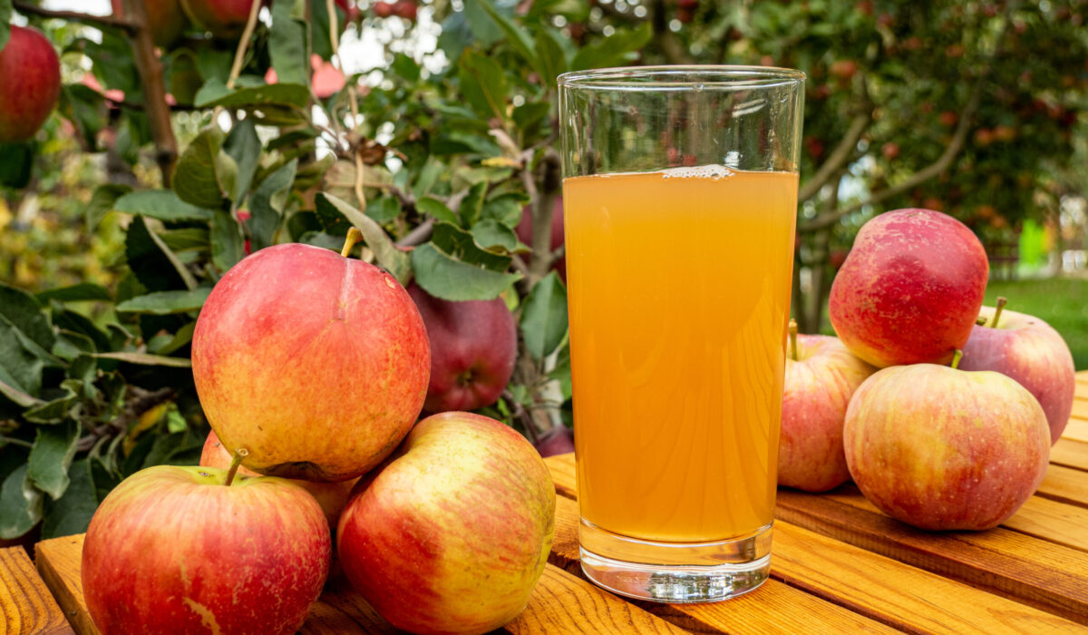 Eine Nahaufnahme von Äpfeln und Apfelsaft auf einem Holztisch