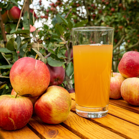 Eine Nahaufnahme von Äpfeln und Apfelsaft auf einem Holztisch