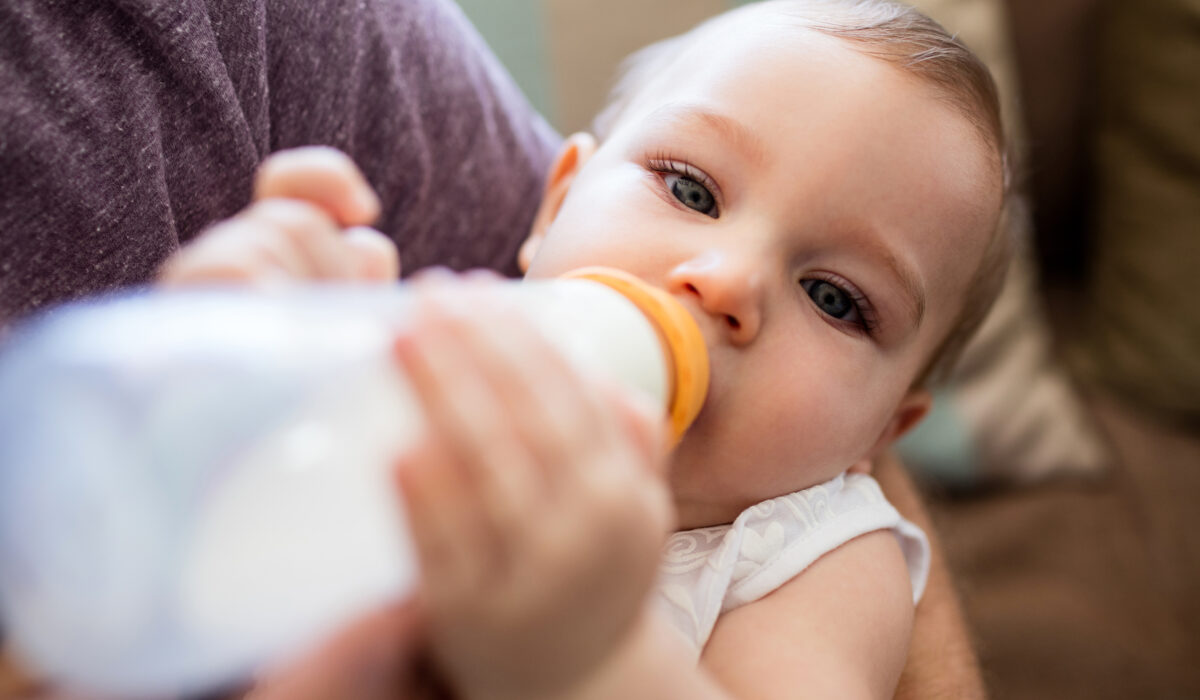 Vater füttert Baby mit einem Milchfläschchen