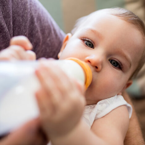 Vater füttert Baby mit einem Milchfläschchen
