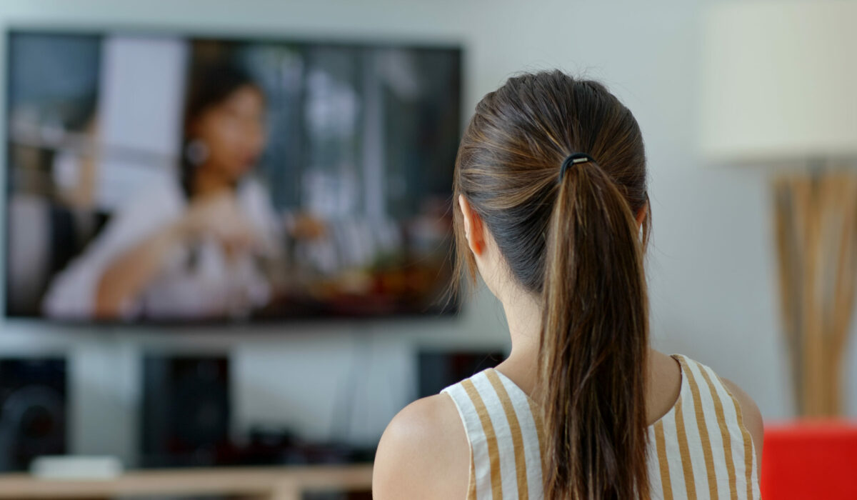 Frau schaut daheim TV