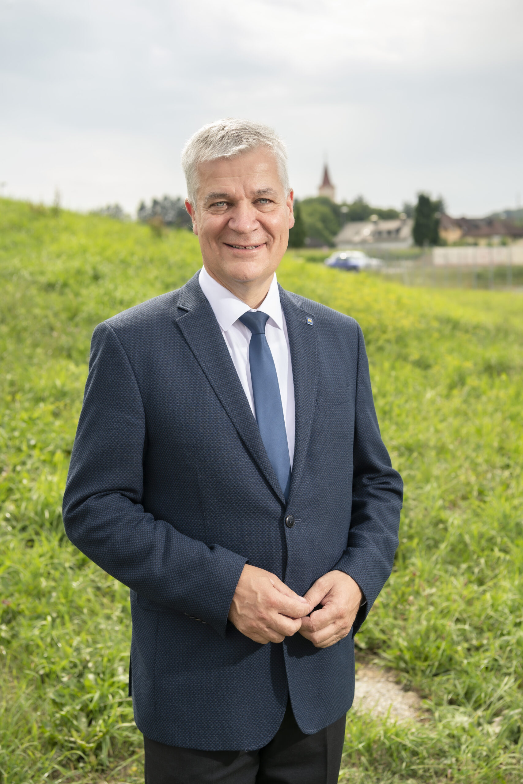 Präsident der NÖ Umweltverbände, Landtagsabgeordneter Anton Kasser steht im Freien, im Hintergrund sieht man einen Ort