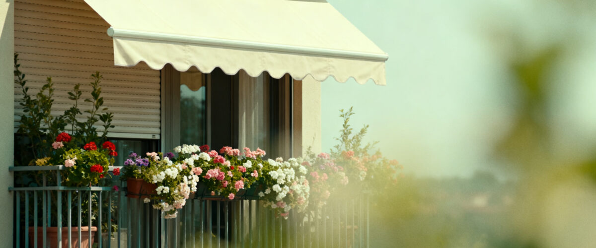 Foto, heißer Sommertag, Balkon mit Blumen und Markise und heruntergelassenen Außenrollos zur Abkühlung