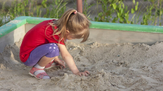 Mädchen spielt in der Sandkiste