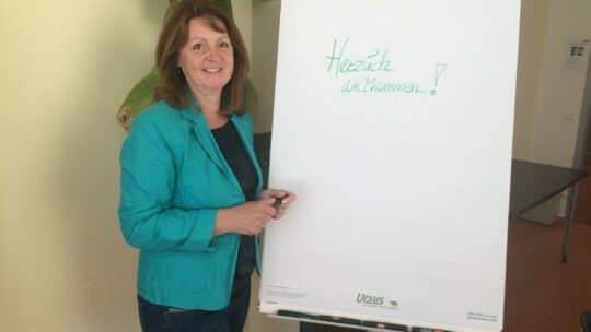 Christa steht vor einem Flipchart.