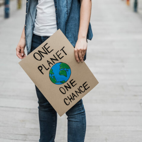 Frau hält Plakat "one planet, one chance" in der Hand