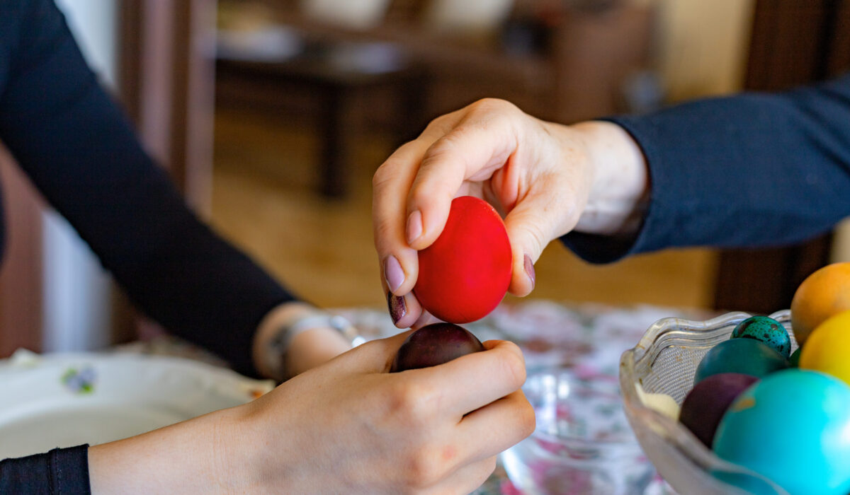 Hände klopfen Ostereier.